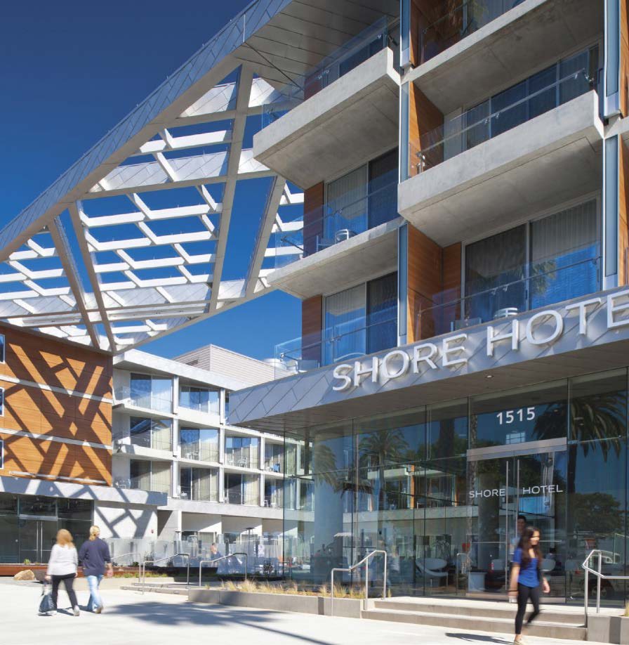Shore Hotel entry elevation in Santa Monica showing the angled white sunshade trellis, timber-screened balconies, and the hotel signage above the glazed ground floor