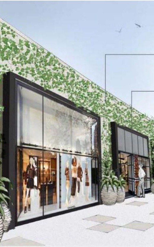 Tenant storefront prototype at Westfield Century City with a dark metal frame, full-height glass, and a living green wall above the entry